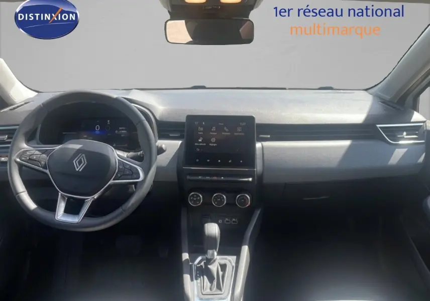 Vue intérieure avant de la Renault Clio blanche 2025, tableau de bord moderne avec écran tactile central et volant multifonction.