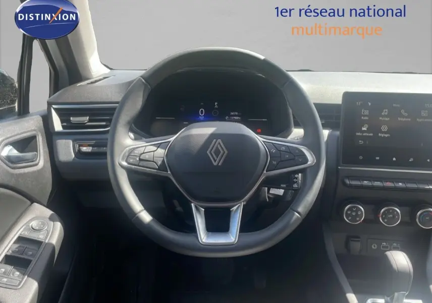 Vue intérieure centrée sur le volant noir Renault avec tableau de bord digital et écran tactile moderne.