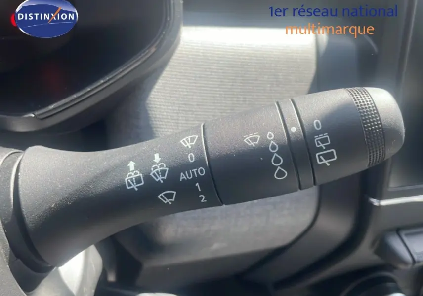 Gros plan sur la commande d'essuie-glace noire dans l'habitacle d'une Renault Clio blanche 2025.