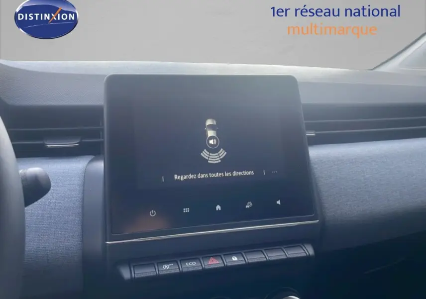 Vue rapprochée de l’écran tactile central du tableau de bord de la Renault Clio blanche, affichant une alerte de sécurité.