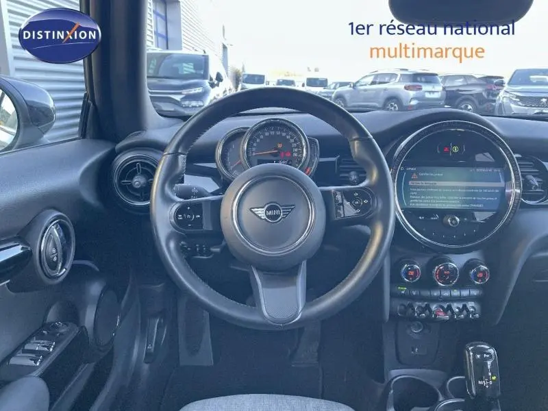 Intérieur de la MINI Cabriolet Cooper 2023 en Midnight Black II, vue centrée sur le volant et le tableau de bord numérique.