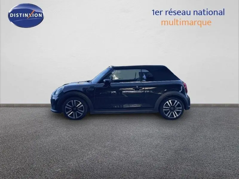 Profil côté gauche d'une MINI Cabriolet Cooper 2023 en Midnight Black II avec capote fermée et jantes alu design.