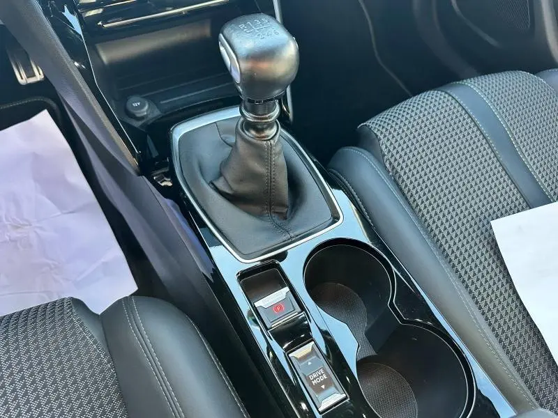 Vue rapprochée de la console centrale noire avec levier de vitesses manuel et sièges tissu gris du Peugeot 2008 GT 2022