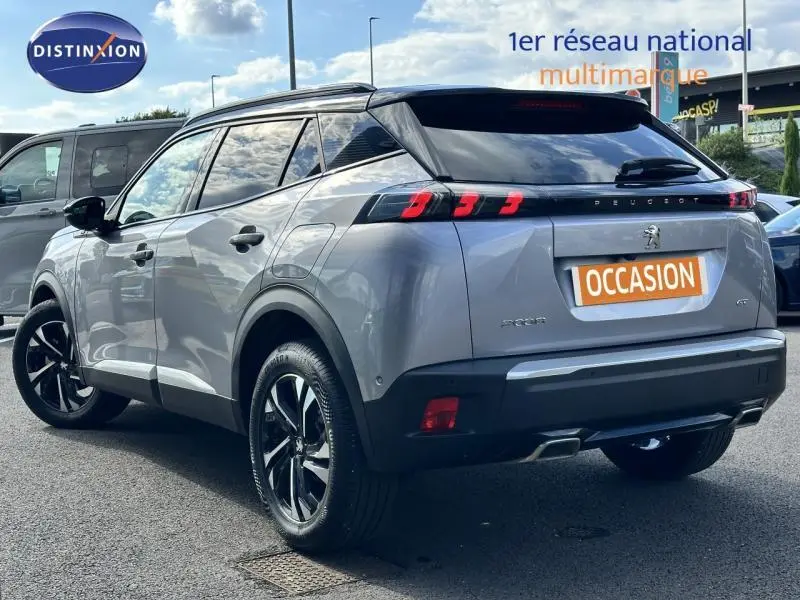 Vue 3/4 arrière droite d'un Peugeot 2008 gris Artense avec feux arrière LED et jantes alliage noires.