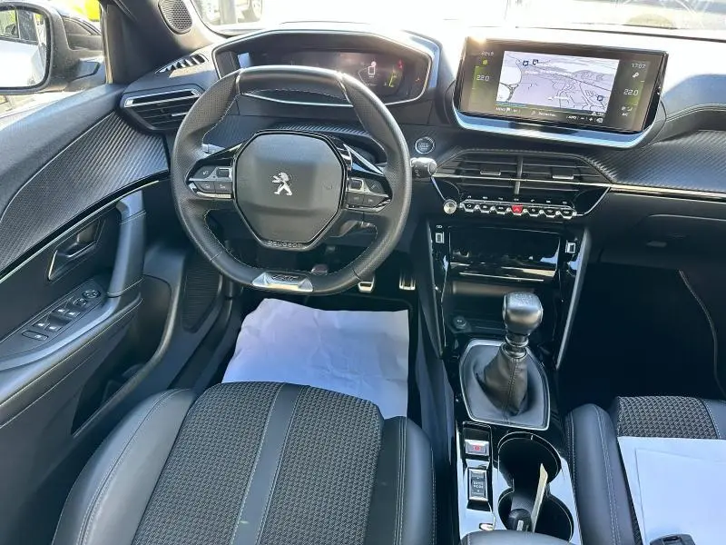 Intérieur de la Peugeot 2008 GT 2022, vue du poste de conduite avec volant cuir multifonction et écran tactile central.