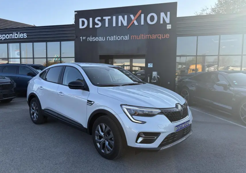 Renault Arkana blanc glacier en 3/4 avant droit, avec jantes alliage grises et rétroviseurs noirs.