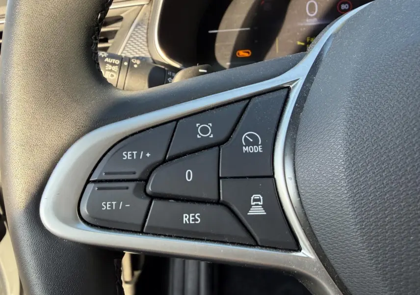 Gros plan sur les commandes du volant en textile noir du Renault Arkana blanc glacier, version 1.3 Mild Hybrid 2025.