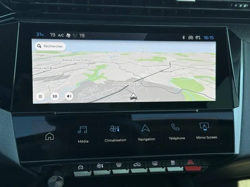 Écran tactile central du tableau de bord de la Peugeot 308 gris 2025, affichant la navigation et les commandes multimédia.