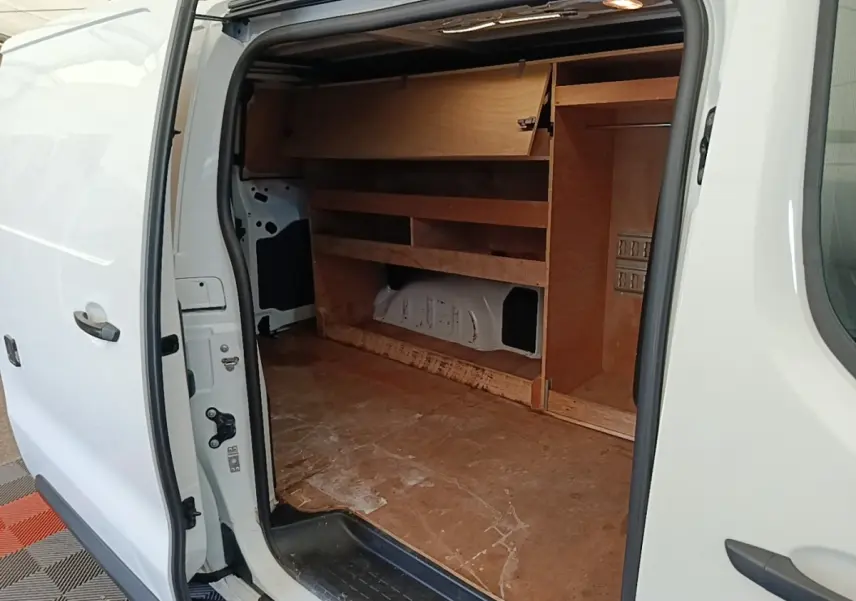 Vue latérale droite d’un Citroën Jumpy blanc 2021 avec porte coulissante ouverte montrant l’aménagement bois intérieur.
