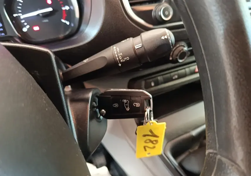 Gros plan sur la clé insérée dans le contact d'un Citroën Jumpy blanc, avec tableau de bord et commandes visibles.