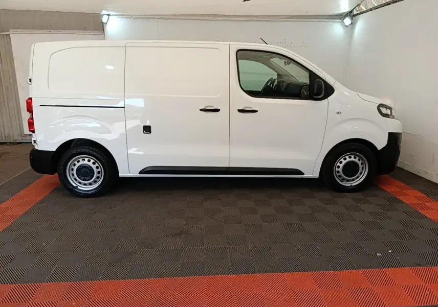 Vue de profil côté gauche d’un Citroën Jumpy blanc utilitaire avec jantes acier et poignées noires.