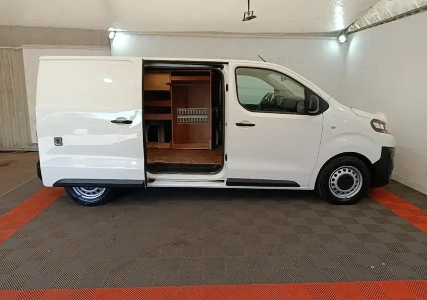 Vue de profil droit d’un Citroën Jumpy blanc 2021 avec porte latérale coulissante ouverte montrant l’aménagement intérieur en bois.