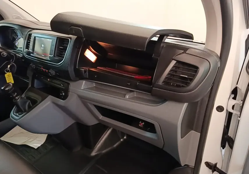 Intérieur du Citroën Jumpy XS 2021 blanc, vue côté passager avec boîte manuelle et boîte à gants ouverte éclairée.