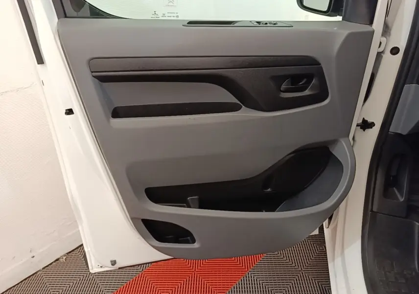 Vue rapprochée de la porte avant gauche blanche du Citroën Jumpy XS BlueHDi 120, avec panneau intérieur gris et noir.