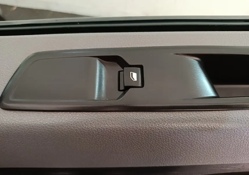 Détail de la commande de vitre électrique intérieure noire sur porte d’un Citroën Jumpy blanc 2021.