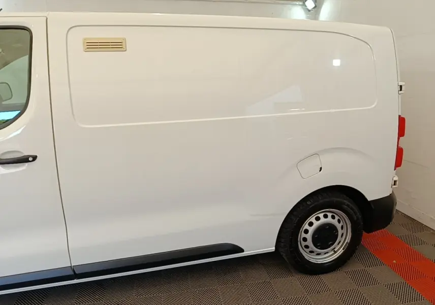 Vue latérale droite d’un utilitaire Citroën Jumpy XS BlueHDi 120 blanc, sans fenêtres latérales, avec jante acier.