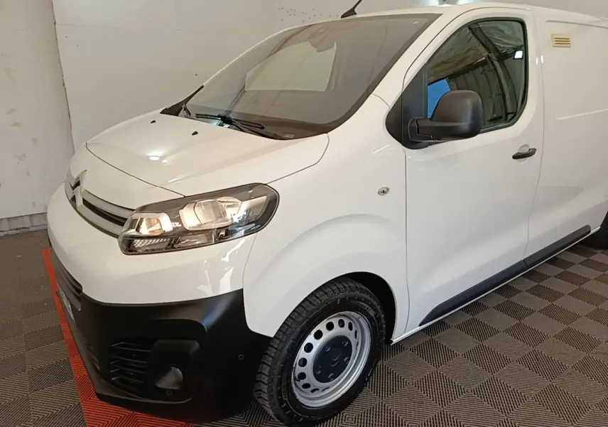 Vue 3/4 avant droit d'un Citroën Jumpy blanc avec pare-chocs noir et jantes acier en intérieur.