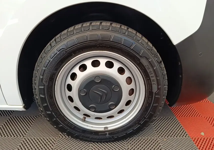 Gros plan sur la roue arrière droite blanche d’un Citroën Jumpy XS BlueHDi 120 avec jante acier et logo Citroën.