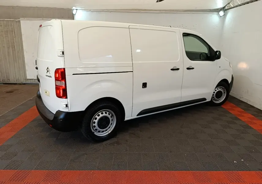 Vue 3/4 arrière côté droit d’un Citroën Jumpy blanc 2021, fourgon utilitaire avec roues acier et pare-chocs noirs.