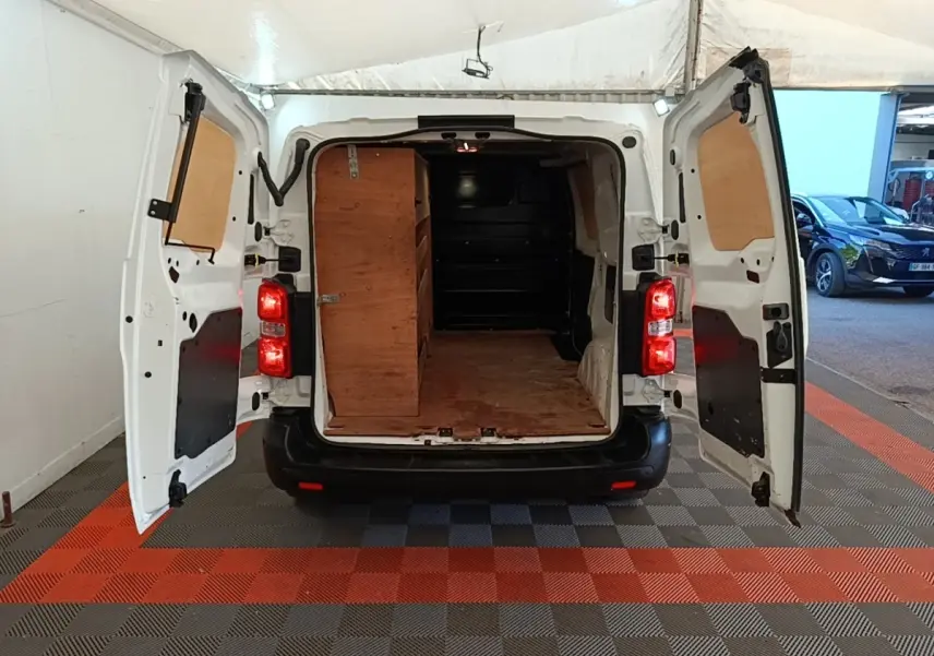 Vue arrière d'un Citroën Jumpy blanc 2021 avec portes ouvertes montrant l'espace de chargement en bois.