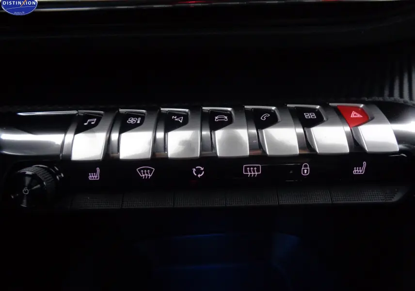 Gros plan sur les commandes centrales chromées du Peugeot 3008 gris Artense, avec boutons fonctionnels rétroéclairés.