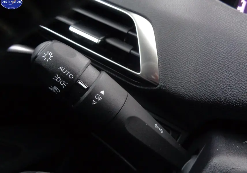 Gros plan sur la commande des phares et clignotants du Peugeot 3008 gris Artense, avec la sortie d'air chromée en arrière-plan.