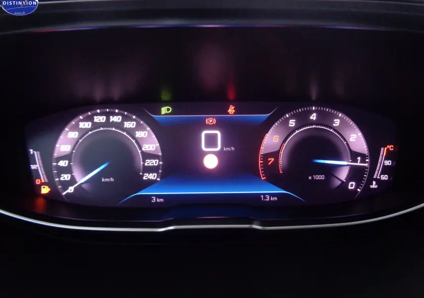 Tableau de bord numérique du Peugeot 3008 2023 affichant vitesse, compte-tours et indicateurs lumineux en intérieur sombre.