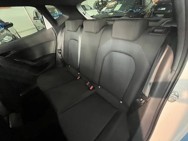 Vue intérieure sur les sièges arrière noirs de la SEAT IBIZA 2024, avec ceinture de sécurité et porte ouverte côté droit.
