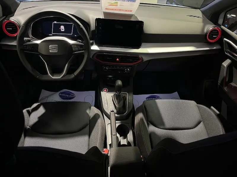 Intérieur de la SEAT Ibiza 2024 vue de face, tableau de bord noir avec touches rouges autour des aérateurs.