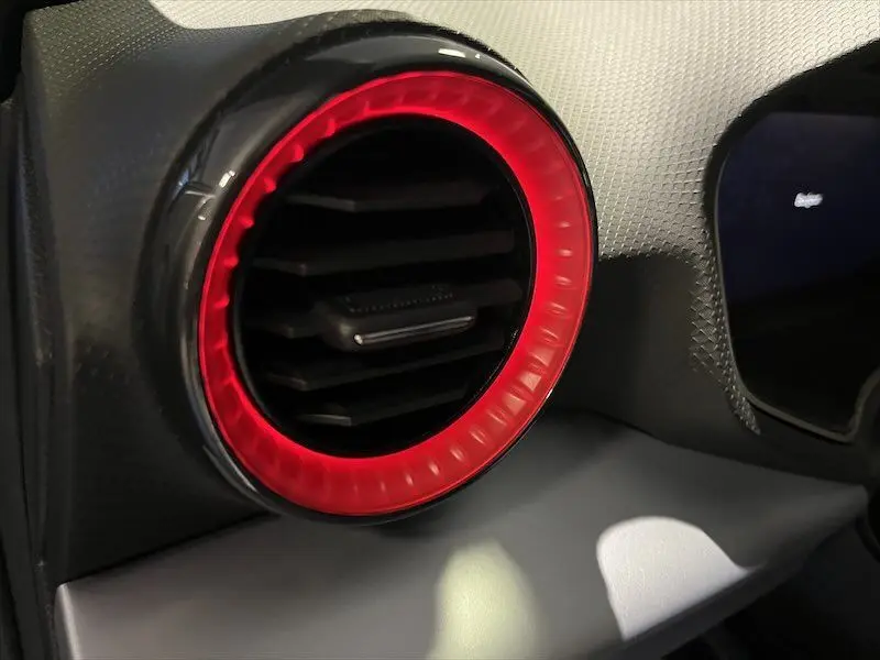 Gros plan sur la sortie d'air circulaire avec anneau lumineux rouge à l'intérieur du tableau de bord d'une SEAT IBIZA 2024.