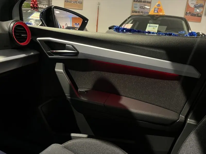 Intérieur côté gauche de la SEAT IBIZA 2024 avec garniture noire et insert rouge autour de la sortie d'air.