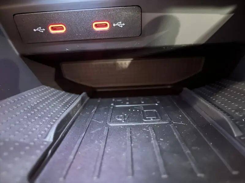 Gros plan sur la zone de recharge sans fil et deux ports USB rouges à l'avant de la console centrale d'une SEAT Ibiza 2024.