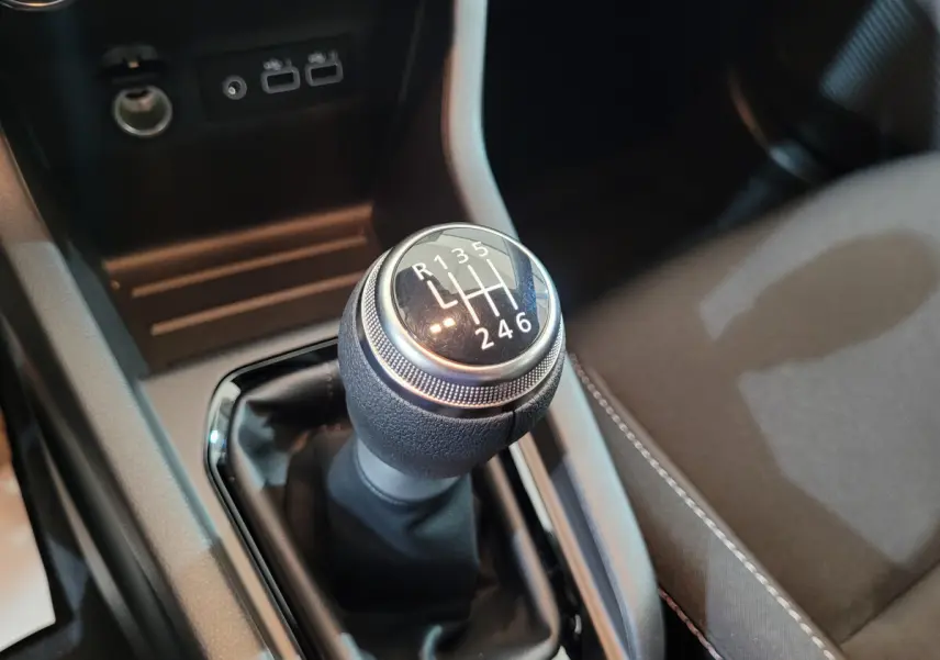Le levier de vitesses manuel de la Renault Clio gris foncé, vue rapprochée de la console centrale intérieure.
