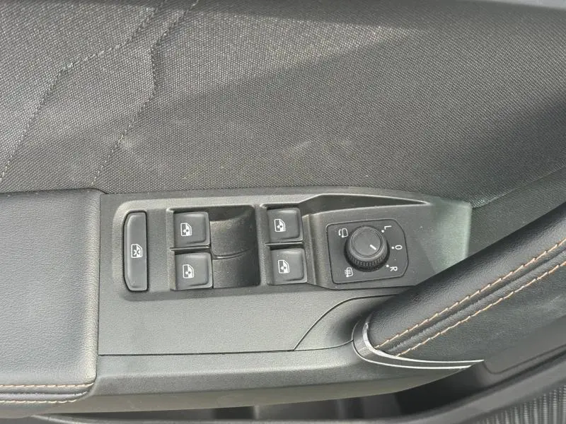 Gros plan sur les commandes des vitres et rétroviseurs côté conducteur du CUPRA Formentor 2025 avec surpiqûres marron.