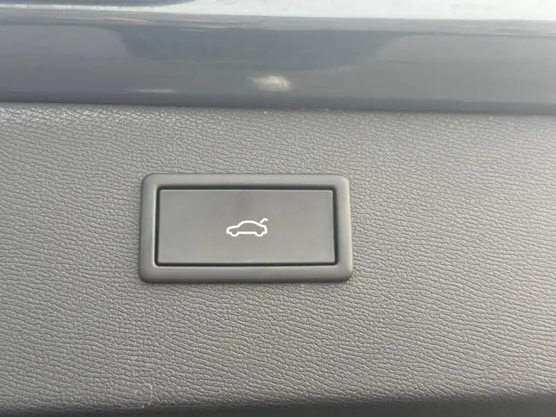 Bouton noir de commande d'ouverture électrique du coffre sur tableau de bord texturé, intérieur CUPRA Formentor 2025.