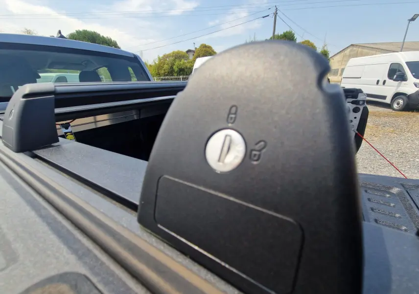 Gros plan sur le verrouillage du rideau de plateau rigide du Ford Ranger Super Cabine gris Iconic, vue arrière extérieure.