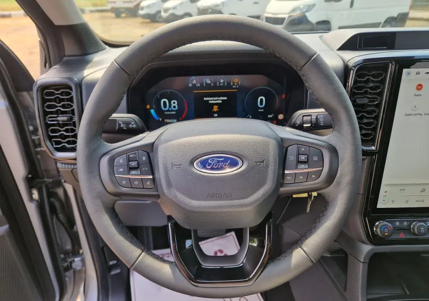 Vue centrée sur le volant cuir noir du Ford Ranger Super Cabine 2026 avec tableau de bord numérique et écran tactile.