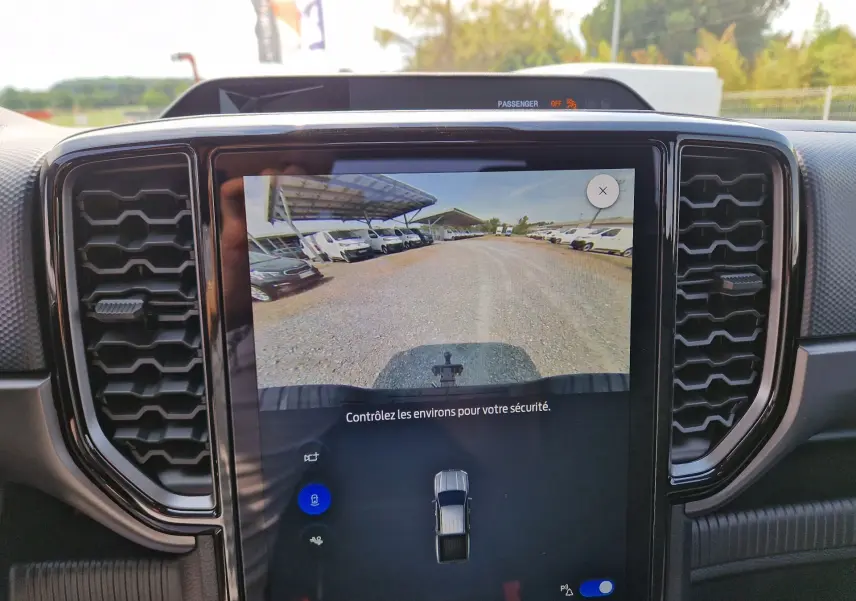 Écran tactile intérieur du Ford Ranger Super Cabine 2026 montrant la caméra de recul avec vue sur un chemin gravillonné.