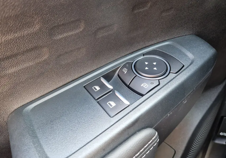 Gros plan sur les commandes de réglage des vitres et des rétroviseurs côté conducteur du Ford Ranger Super Cabine gris Iconic 2026.