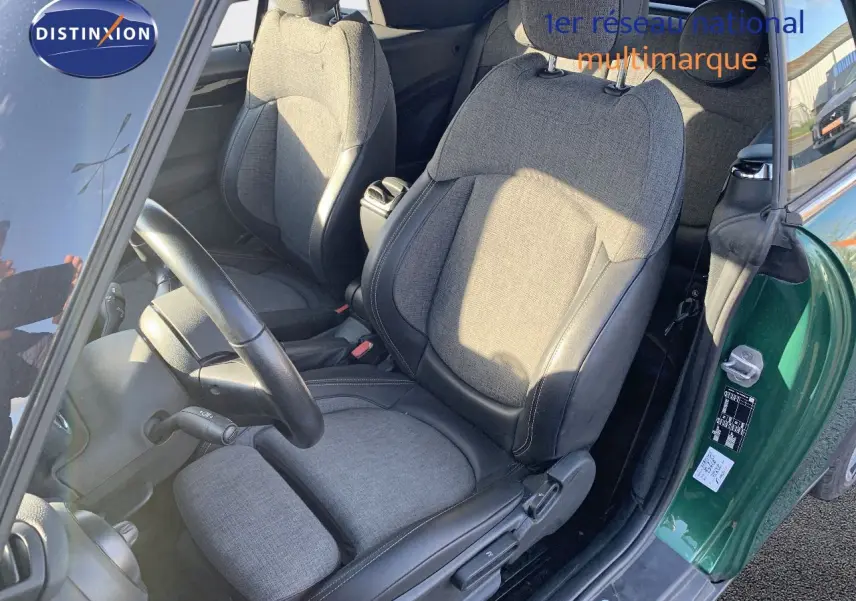 Vue intérieure côté conducteur d'une MINI Cabriolet British Racing Green avec sièges tissu et cuir noir.