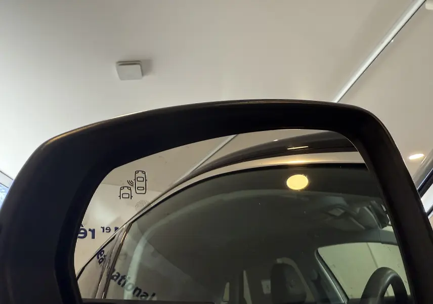 Rétroviseur côté gauche d’un Opel Grandland X gris Himalaya, reflet intérieur avec volant et siège conducteur visibles.