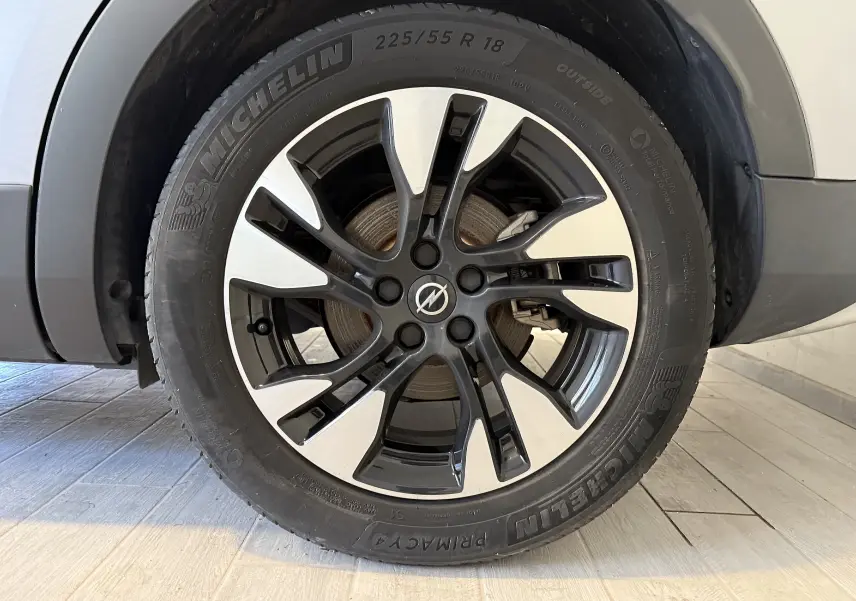 Gros plan sur la roue avant droite d'un Opel Grandland X gris Himalaya, jante alliage bicolore et pneu Michelin.