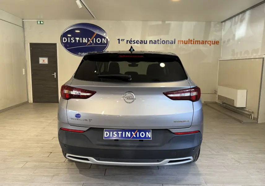 Vue arrière de l'Opel Grandland X gris Himalaya métal en hybride rechargeable, avec logo et feux arrière LED visibles.