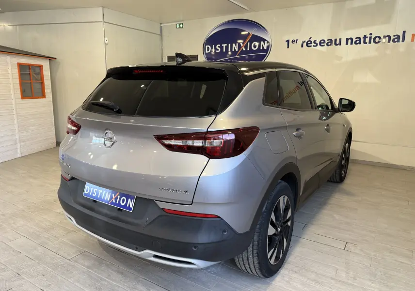 Vue 3/4 arrière droite d'un Opel Grandland X gris Himalaya hybride rechargeable avec toit noir et jantes noires.