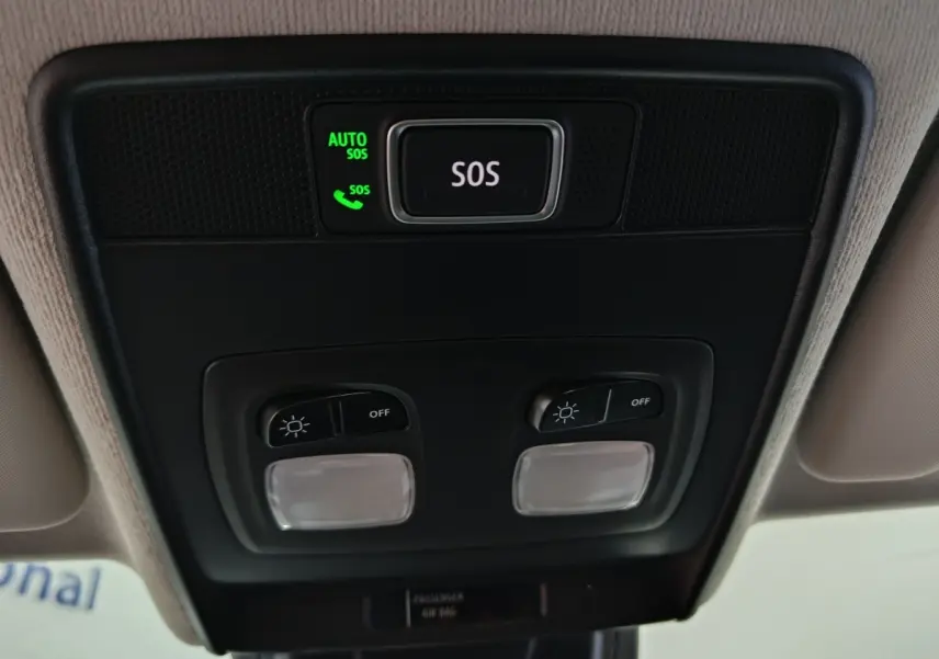 Vue en gros plan du plafonnier noir avec bouton SOS illuminé vert sur Renault Clio gris clair Evolution Blue dCi 2025.