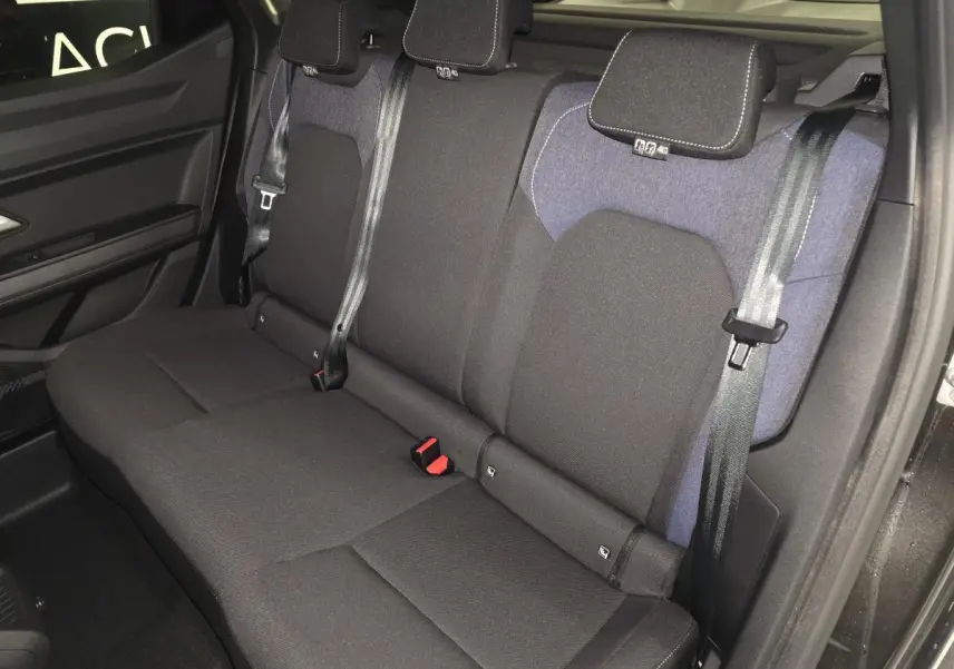 Vue de côté gauche sur la banquette arrière noire et denim bleu du Dacia Duster 1.6 Hybrid 2025 avec ceintures trois points.