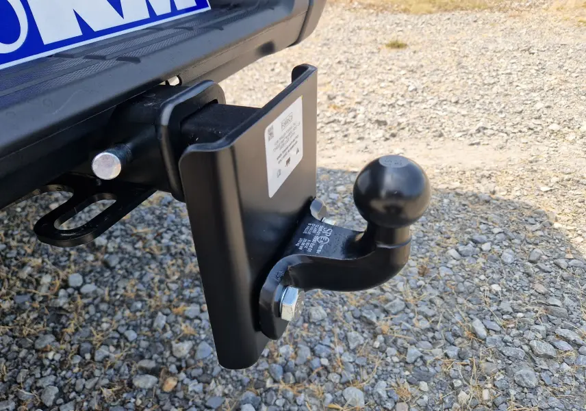 Gros plan sur l’attelage arrière noir du Ford Ranger Super Cabine gris carbone, posé sur un sol gravillonné.