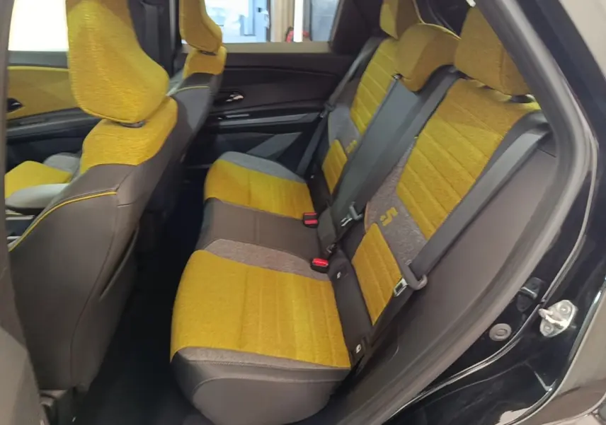 Vue intérieure côté droit montrant les sièges arrière jaunes et gris du Renault R5 Iconic Cinq 2024 électrique.