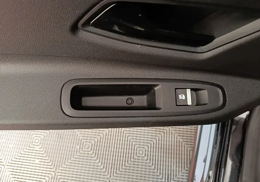 Gros plan sur la commande de verrouillage de porte noire côté intérieur d'une Renault R5 Iconic 2024.