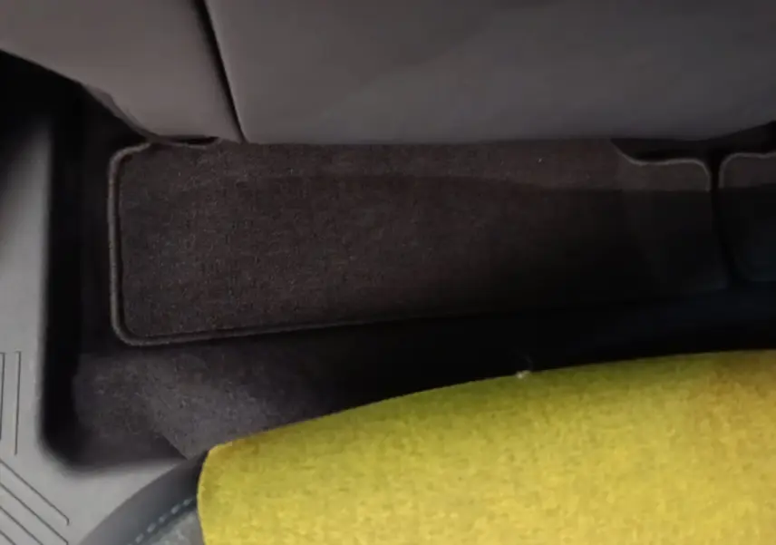 Détail de la moquette noire et de l'assise verte à l'arrière de la Renault R5 Iconic Cinq 2024 électrique.